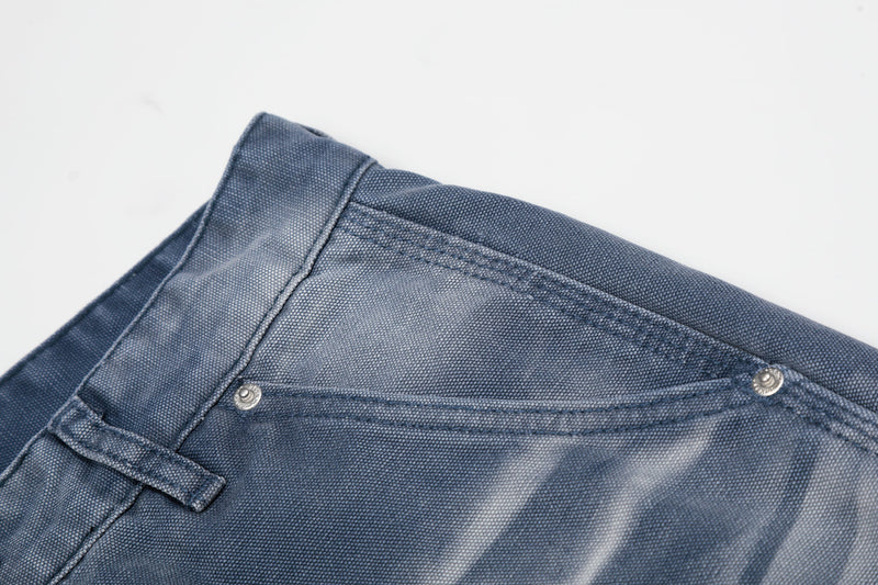 Close-up of blue denim waistband corner and front pocket stitching