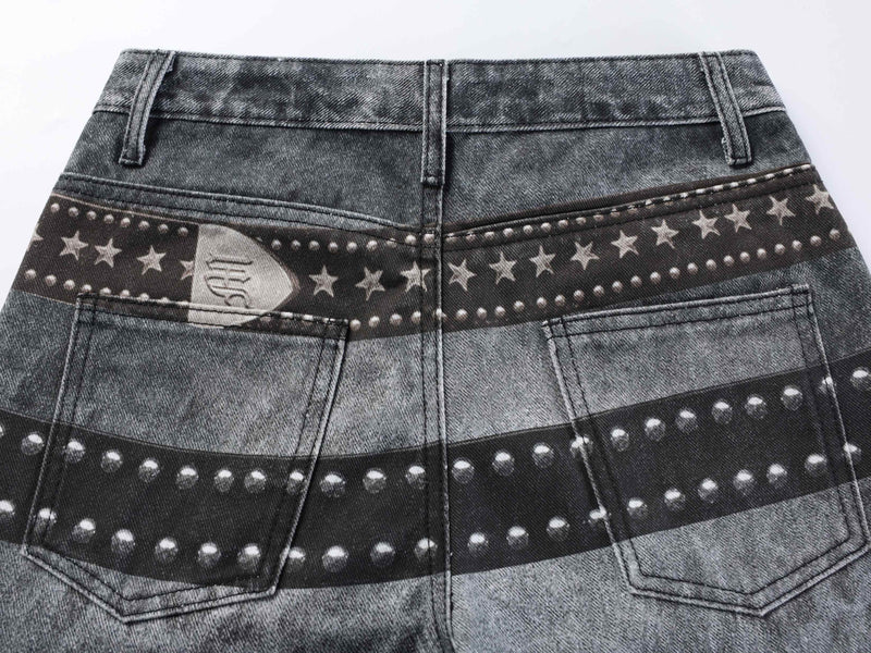 Close-up of back waistband on washed black jeans with star and stud print across the yoke