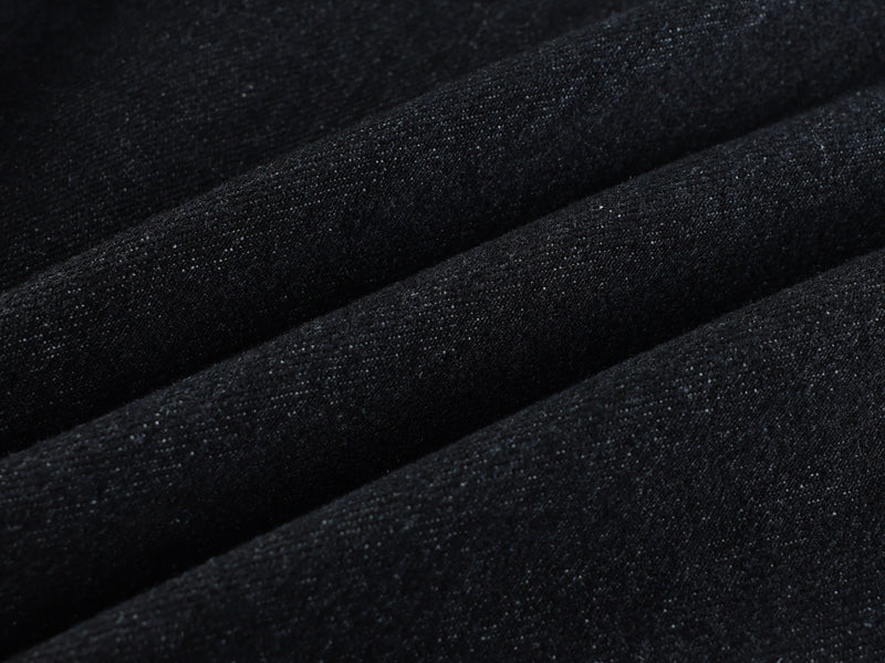 Close-up of black denim fabric with visible weave and soft folded texture