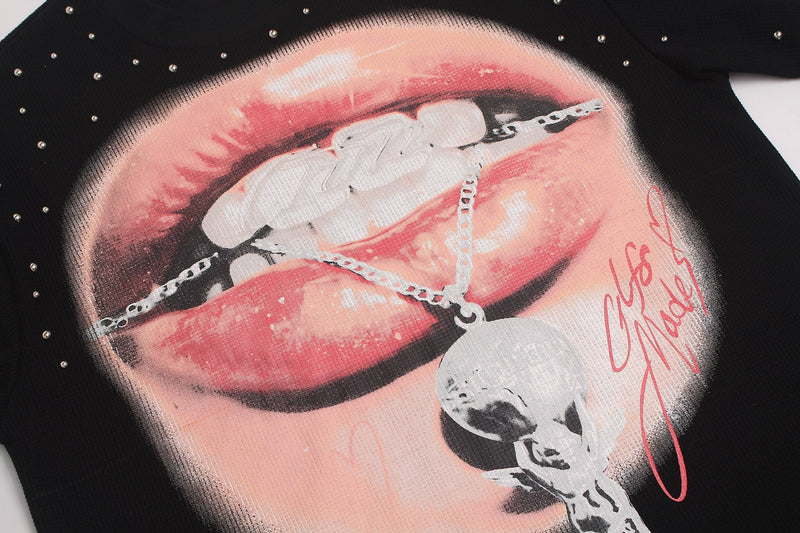 Black oversized T-shirt with rhinestone lip graphic and dangling chain detail in bold Y2K streetwear style
