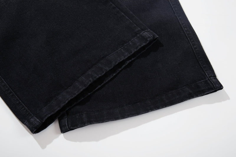 Close-up of the cuffed hem and seam on black denim