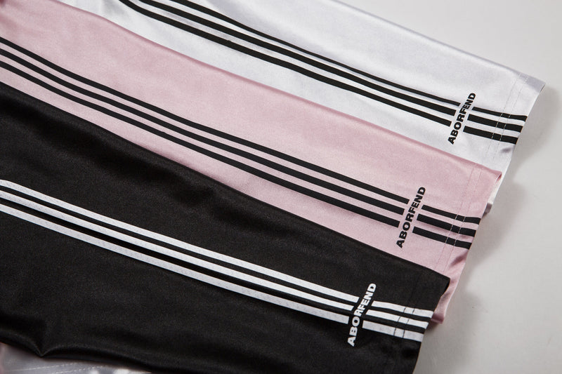Diagonal layflat view of jersey sleeves with black stripes and ABORFEND print