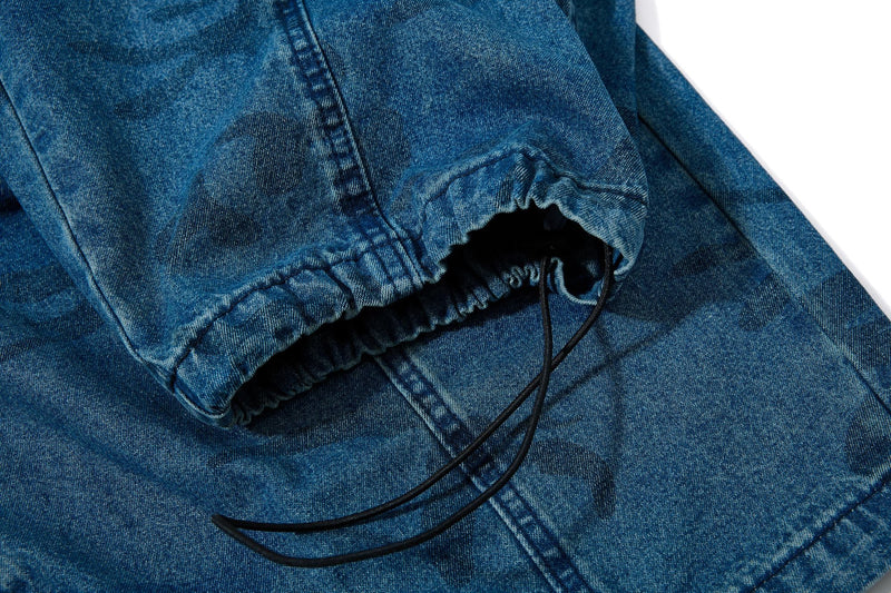 Close-up of cuffed elastic hem with drawstring on washed blue camo jeans