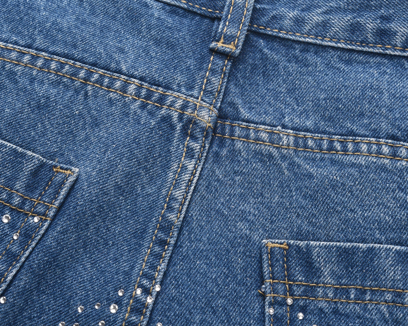 Close-up of blue denim shorts back waistband and belt loop stitching
