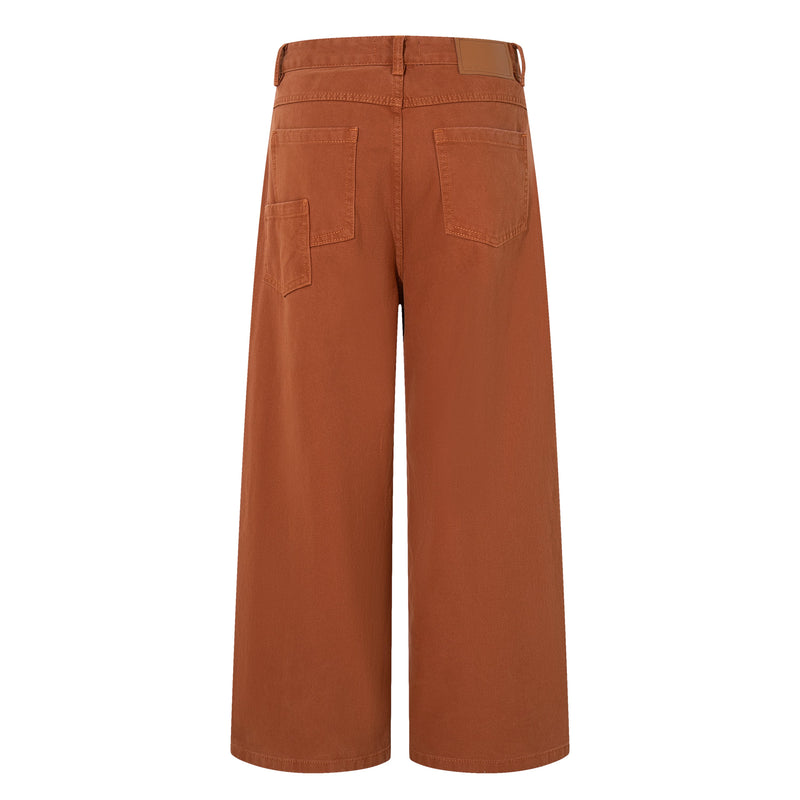 Back view of rust brown wide-leg jeans with patch pockets and a leather logo patch