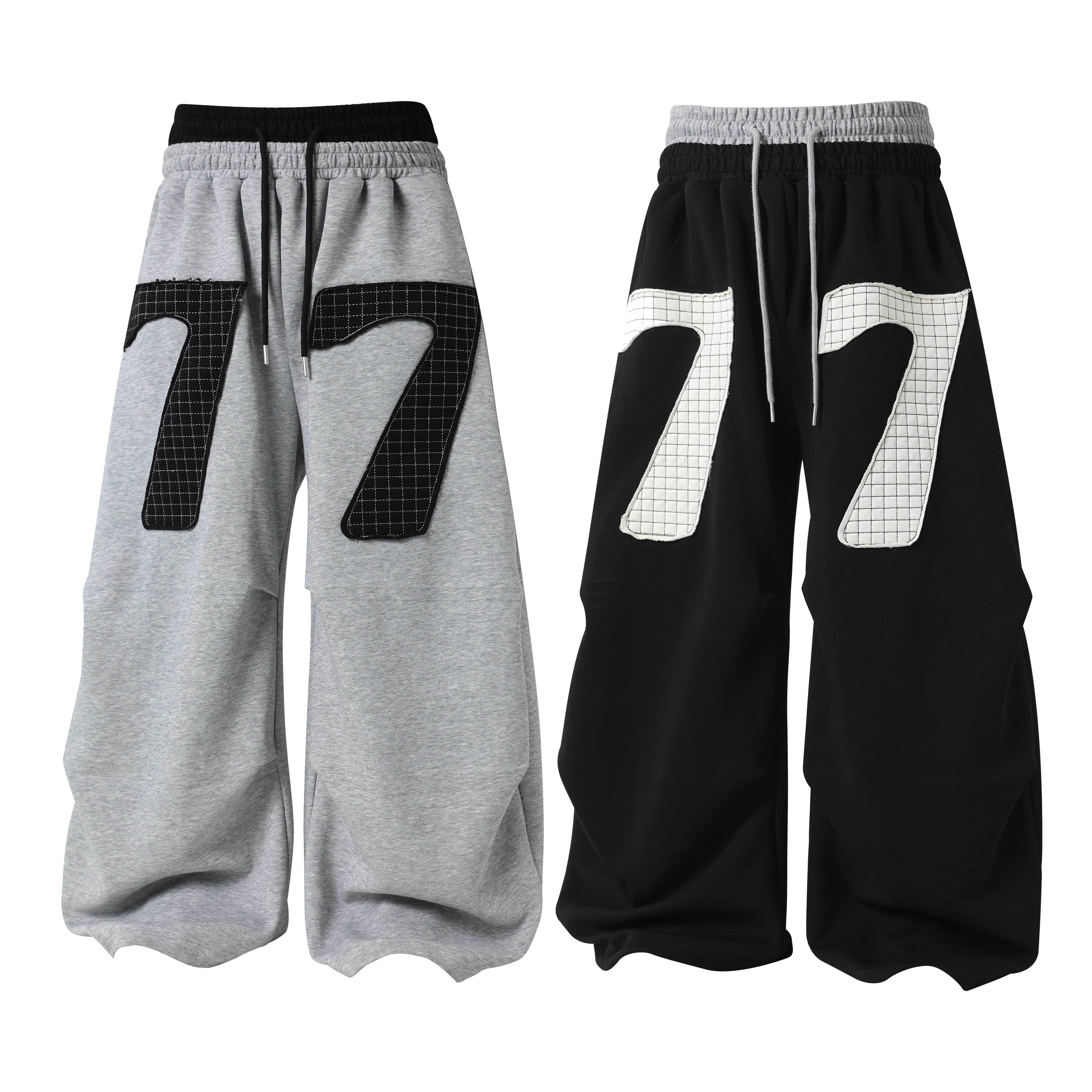 Heather grey and black wide-leg sweatpants with oversized 77 grid-stitch patch appliqué, shown front view side by side