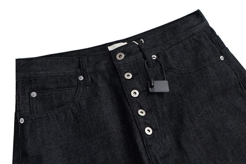 Close-up of the waistband and button fly on dark denim jeans