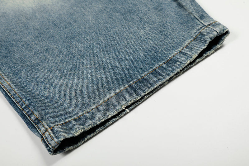 Close-up of the hem on light wash wide-leg jeans with raw edge and stitched cuff