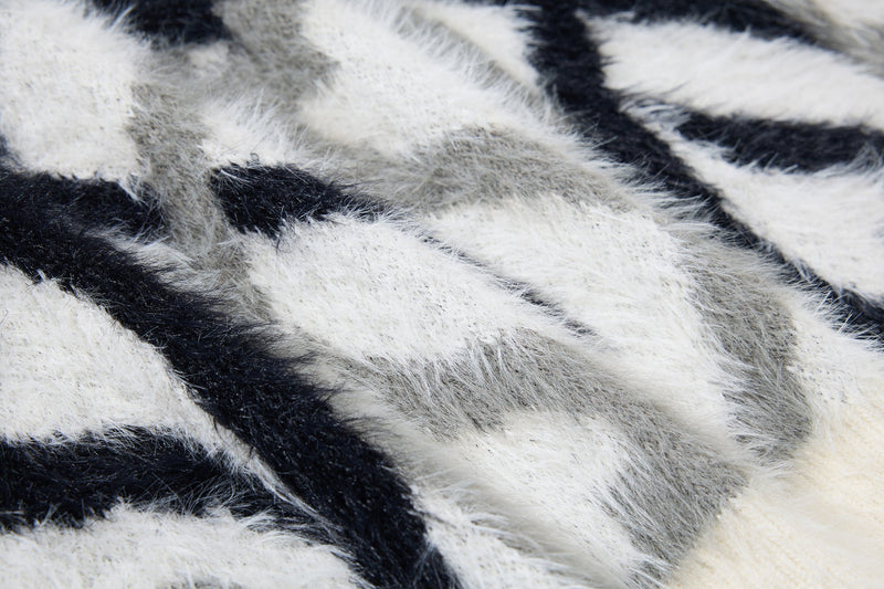 Close-up of black and white faux-fur fabric with abstract flame pattern