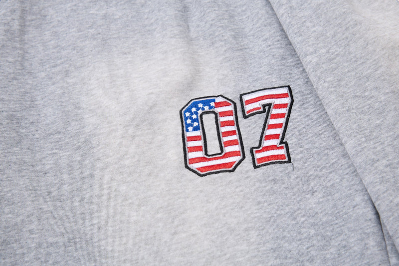 Close-up of 07 embroidered patch on light gray athletic shorts