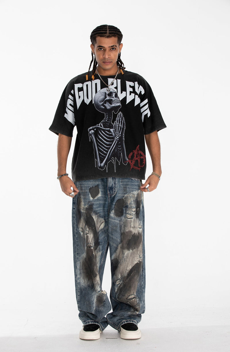 Black oversized gothic graphic tee with a praying skeleton print and bold Blessed Bones lettering on the front
