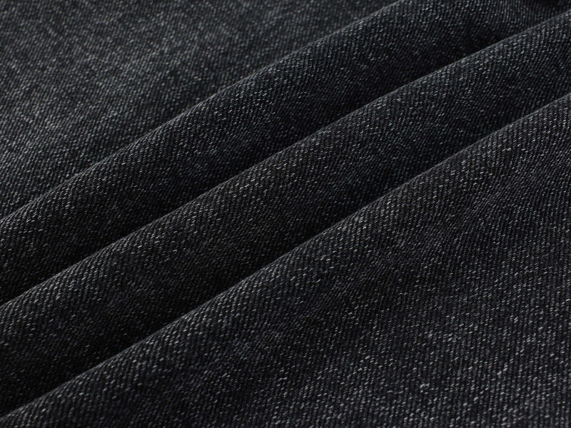 Close-up of black denim fabric texture with diagonal folds