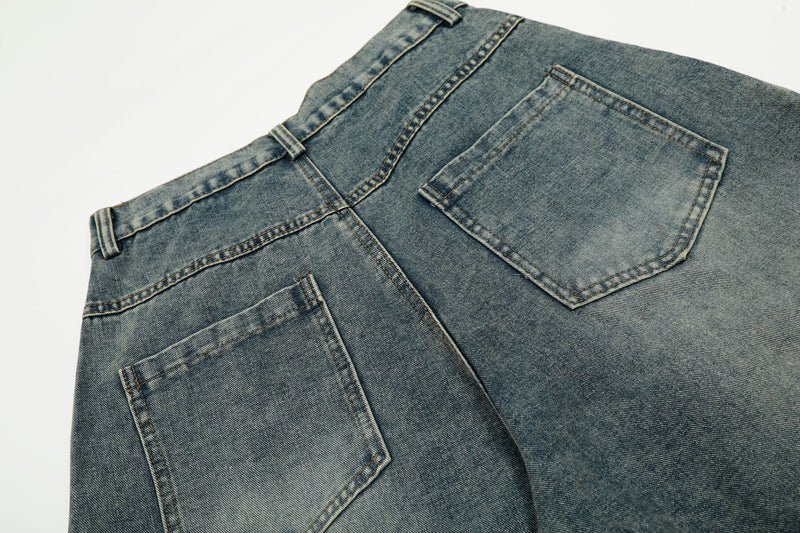 Close-up of back pockets and waistband on blue wide-leg denim jeans