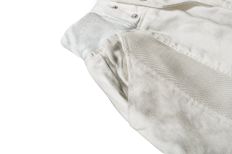 Close-up of side panel texture and snap detail on light gray wide-leg shorts