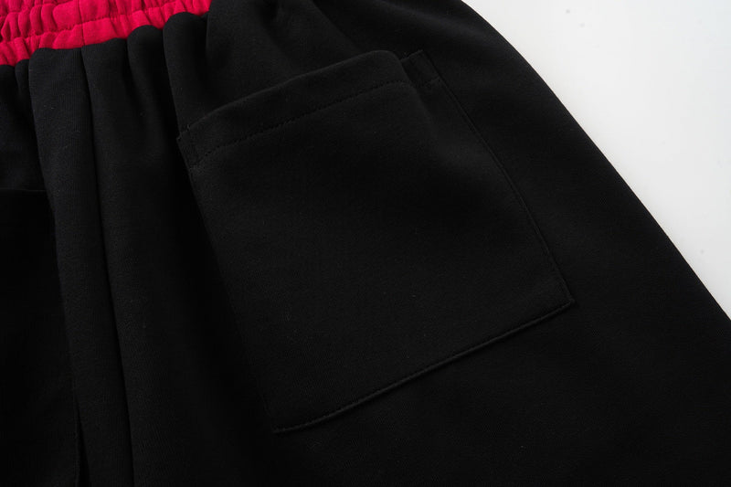 Close-up of black rear pocket on sport shorts with magenta waistband