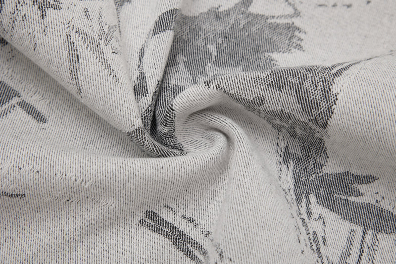 Close-up of wrinkled gray denim fabric with abstract black ink-wash print