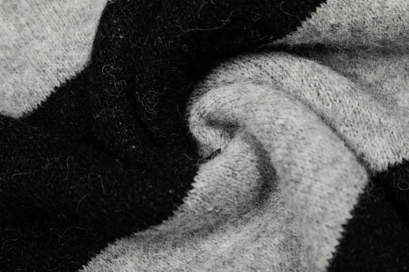 Close-up of folded black and gray knit fabric with star pattern