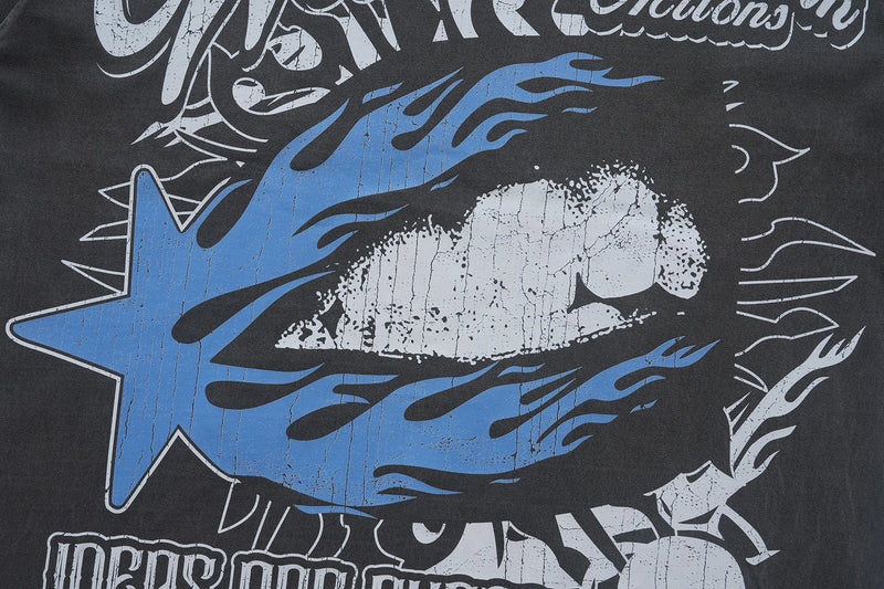 Close-up of a black vintage washed graphic T-shirt with bold blue and white distressed flame lettering design
