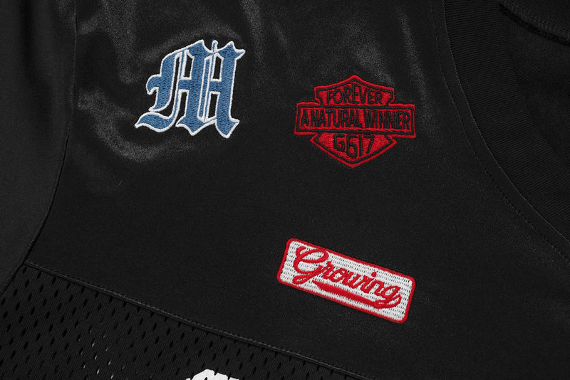 Black patchwork mesh football jersey tee with embroidered patches and graphic streetwear detailing