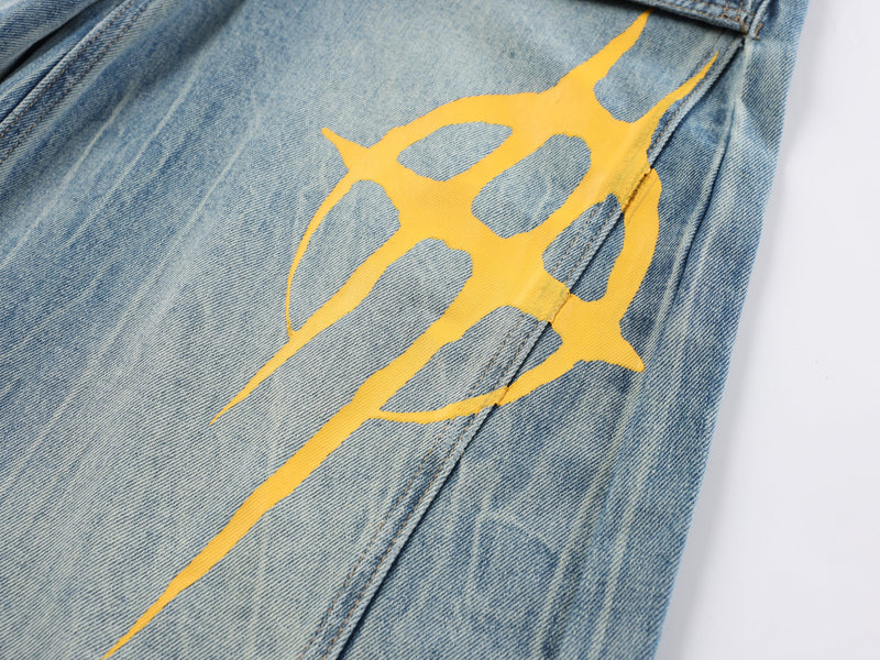 Close-up of a large yellow graphic print on the leg of light blue jeans