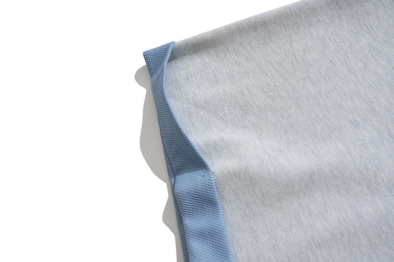 Close-up of light gray varsity graphic tee with blue ribbed trim and textured cotton fabric on a white background