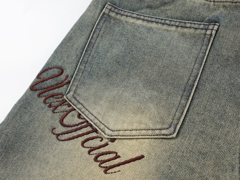 Back pocket close-up with cursive embroidery on vintage wash denim