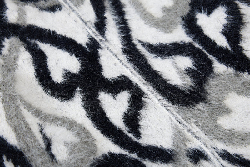 Close-up of black and white faux-fur hoodie pattern with dense shaggy texture