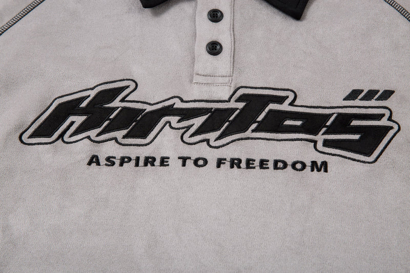 Close-up of front logo print on the light gray long-sleeve polo shirt