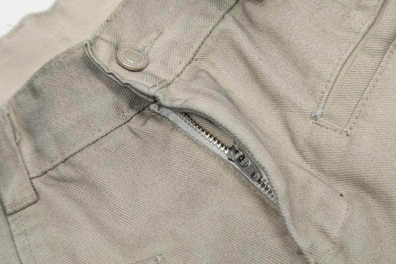 Close-up of front waistband, snap button, and zipper on grey cotton pants