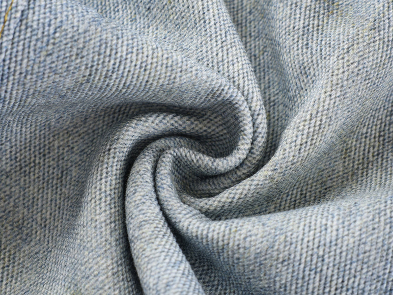 Close-up of soft light denim fabric twisted into a spiral