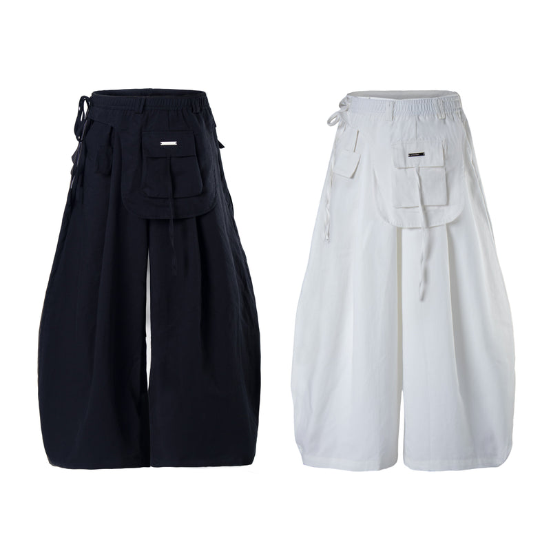 Wide-leg cargo pants in black and white, front view with layered utility pockets