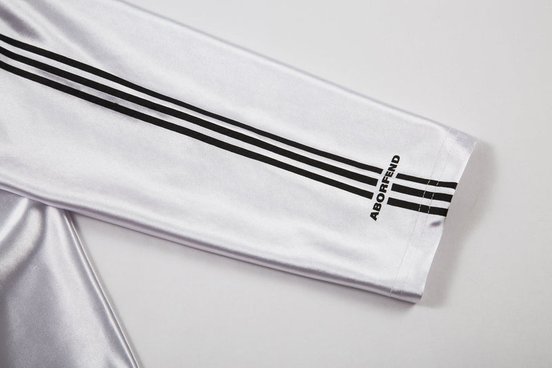 Close-up of white sleeve with triple black stripes and ABORFEND print at cuff