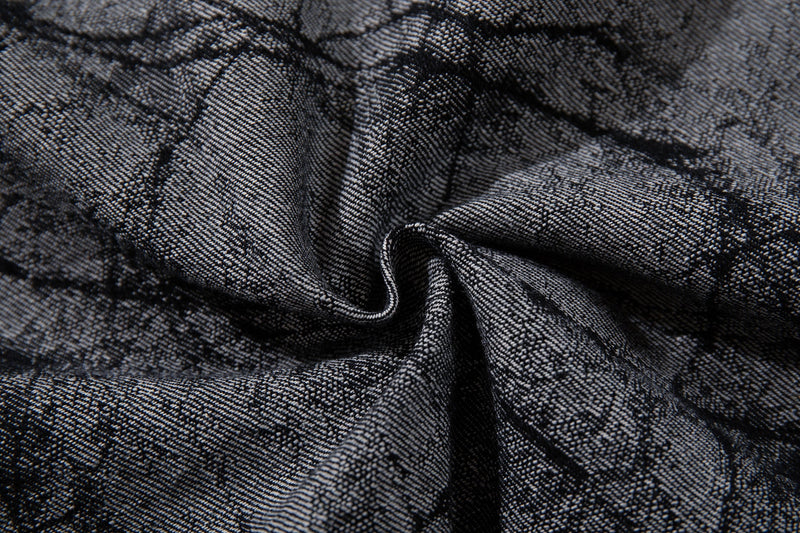 Close-up of gathered gray denim fabric with cracked print texture