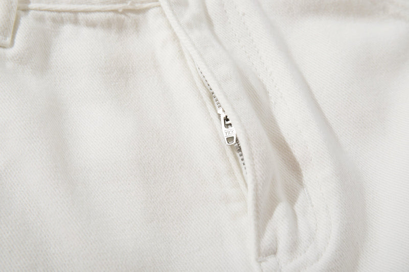 Close-up of the front fly zipper on white denim with YKK zipper pull