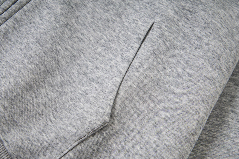 Close-up of front pocket seam on light gray zip hoodie