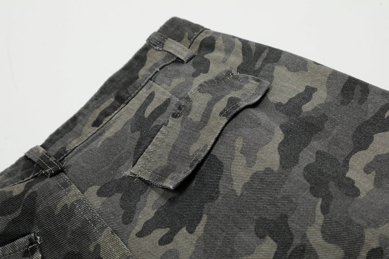 Close-up of camouflage shorts cargo pocket and waistband seam on gray-black fabric