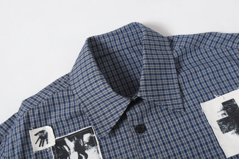 Close-up of plaid shirt collar and chest with patchwork graphic detail