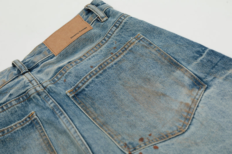 Close-up of back pocket and waistband on faded wide-leg jeans with patch label and topstitching