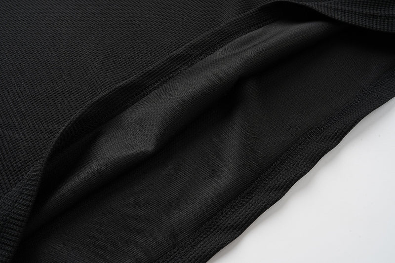 Close-up of black Henley shirt hem with inside seam and waffle texture