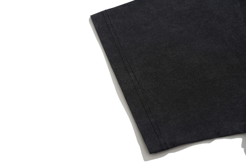 Black vintage wash graphic T-shirt sleeve cuff detail on a clean white background