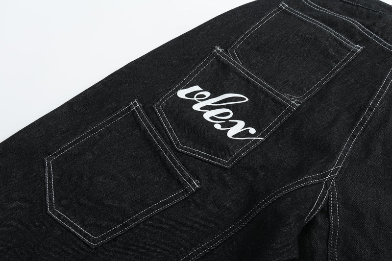 Back pocket with white cursive graphic on black denim shorts