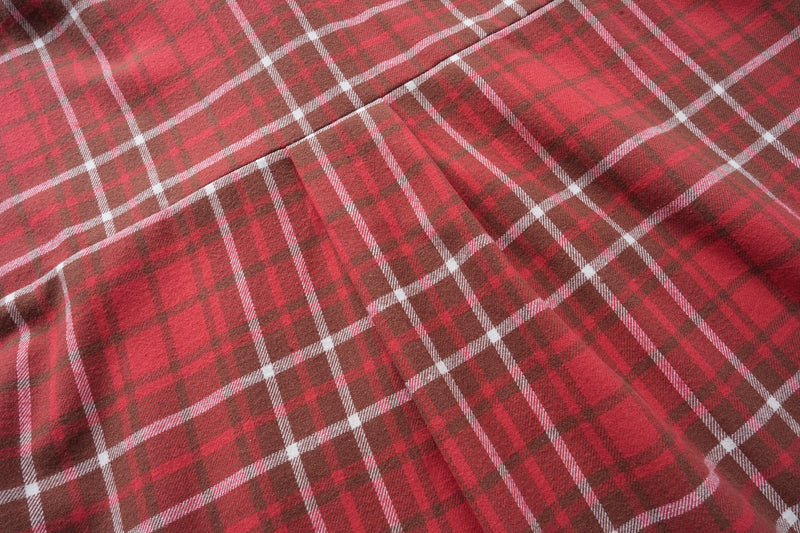 Flat view of red plaid flannel fabric with stitched back yoke seam