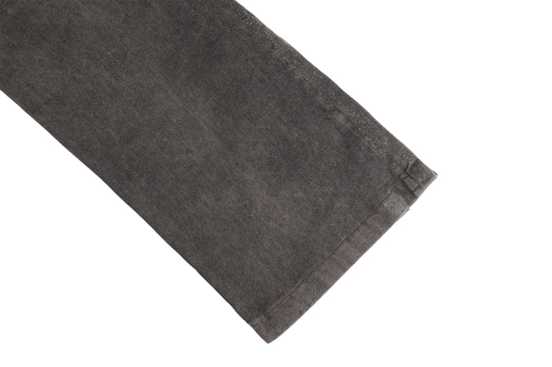 Close-up of dark brown jean leg hem with subtle glitter speckles