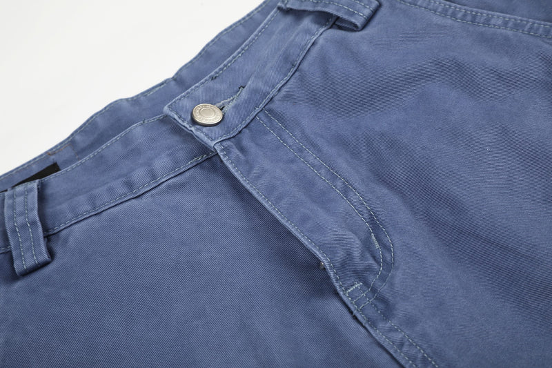 Close-up of blue cargo shorts waistband with button closure and seam detail