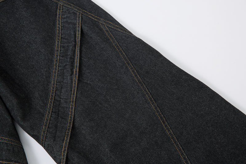 Close-up of side panel seam and diagonal stitching on dark denim pants