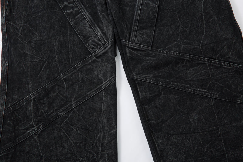 Close-up of lower front legs on black wide-leg jeans with angled seam panels