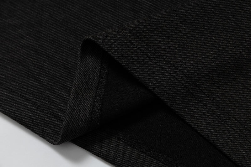 Close-up of black textured fabric with folded hem, showing the material finish of a gothic raglan streetwear T-shirt