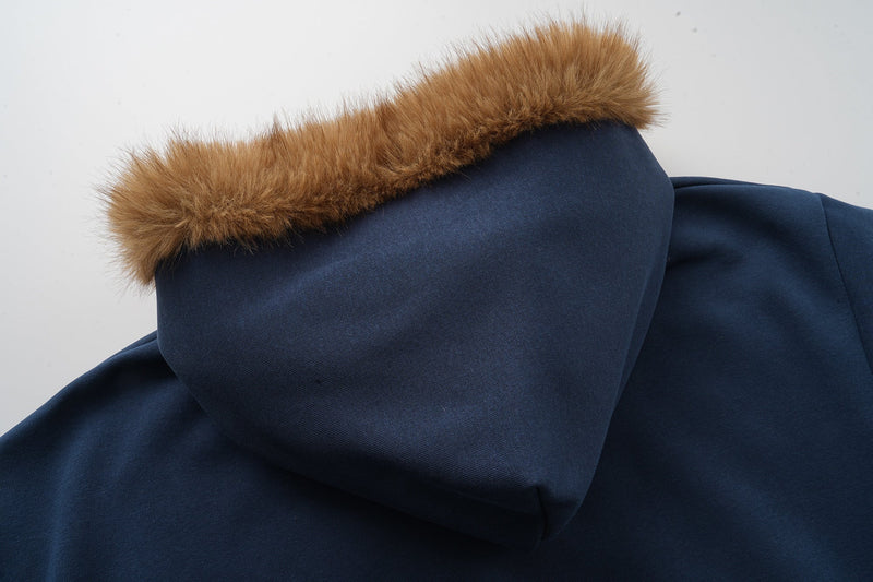 Side close-up of navy hood with brown faux fur trim along the edge