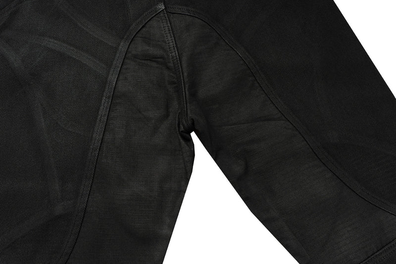 Close-up of black jeans back panel and curved seam detail