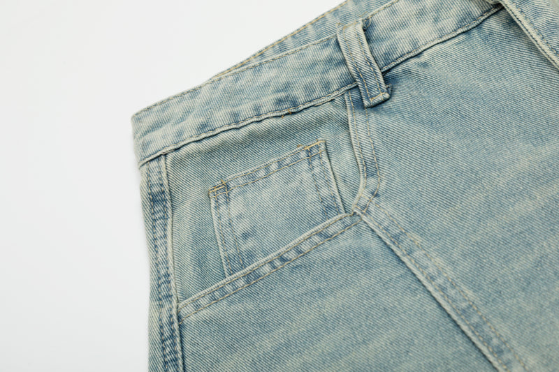 Close-up of back pocket and side seam on light wash denim jeans